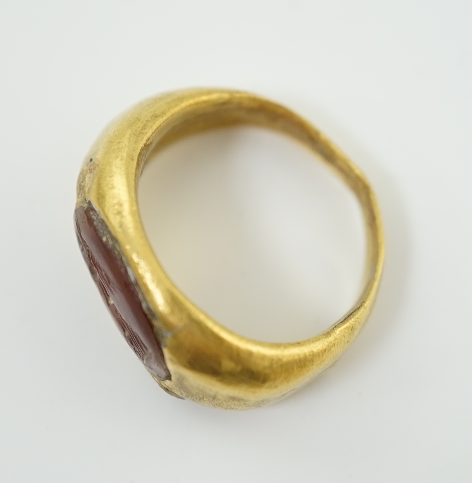 A Greco-Roman gold and intaglio carnelian set finger ring, carved with the figure of Nike, circa 1st century B.C.